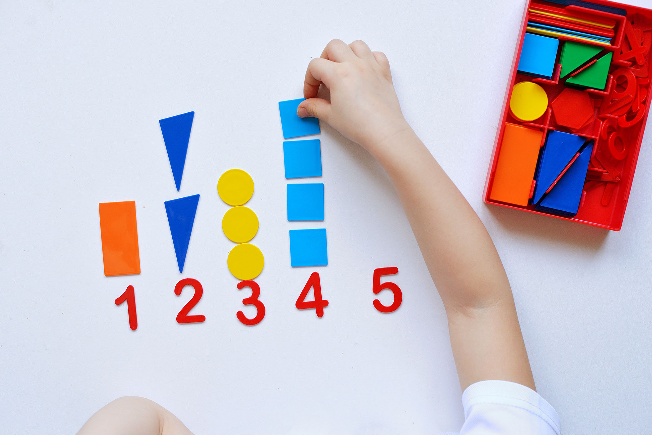 Child working with colourful Montessori number materials