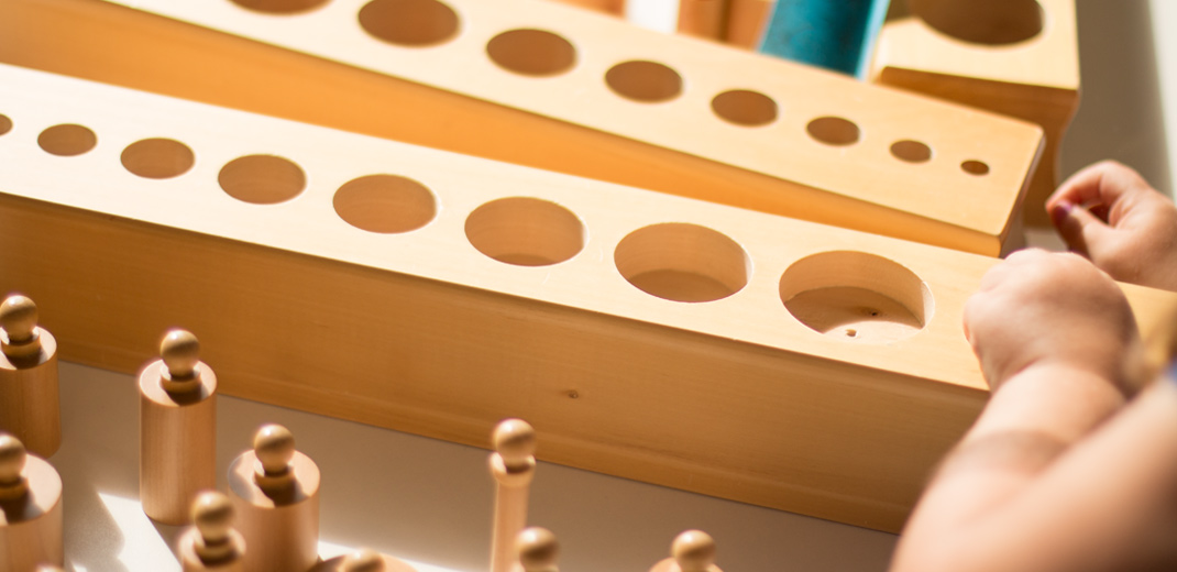 Child using wooden Montessori learning materials